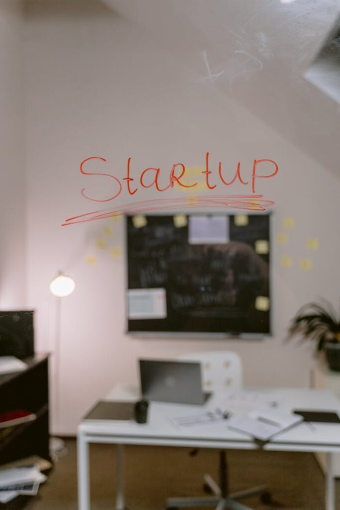 Blurred office view with 'Startup' written on glass, highlighting creative work environment.